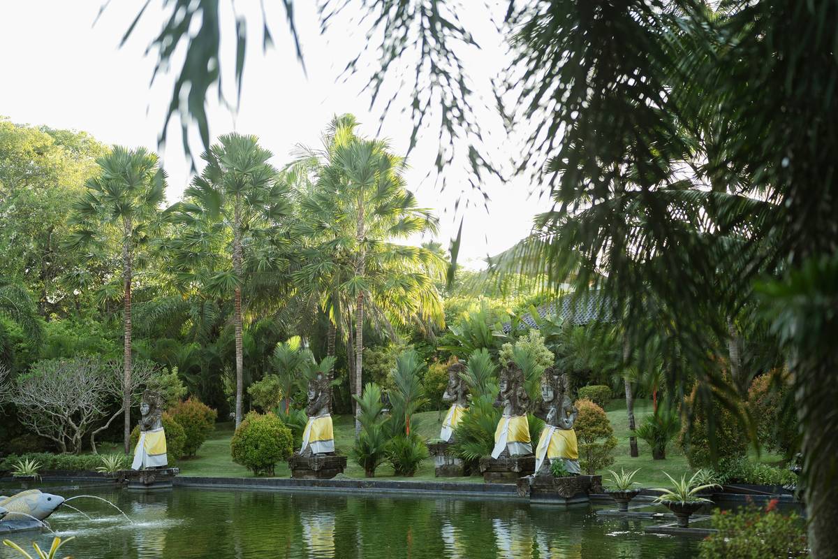 outdoor cactus garden ideas featuring clustered barrel and prickly pear cacti around a stone pathway flanked by minimalist concrete garden statues